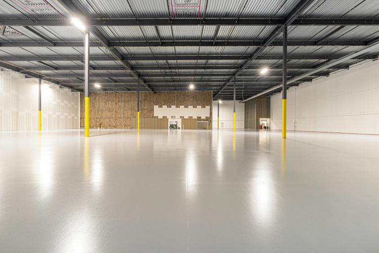 Concrete floors inside brightly lit empty warehouse